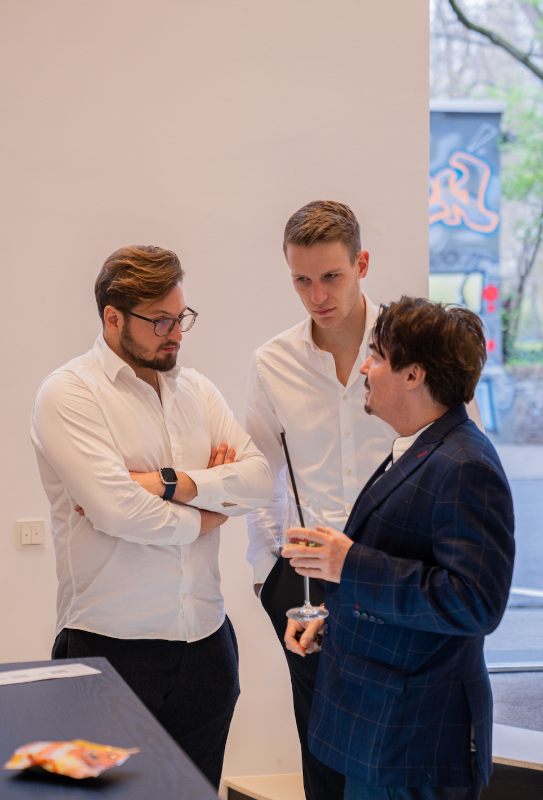 Drei Männer im intensiven Austausch während eines Networking-Events bei MYH&B