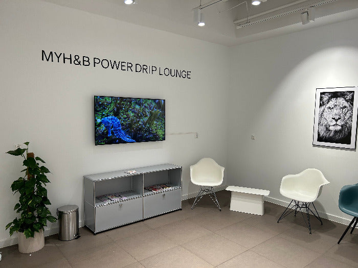 MYH&B Power Drip Lounge mit Sesseln, TV und Wandkunst – stilvoller Wartebereich.