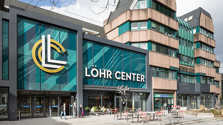Außenansicht des Löhr Centers in Koblenz mit markantem LL-Logo und Sitzbereich vor dem Eingang