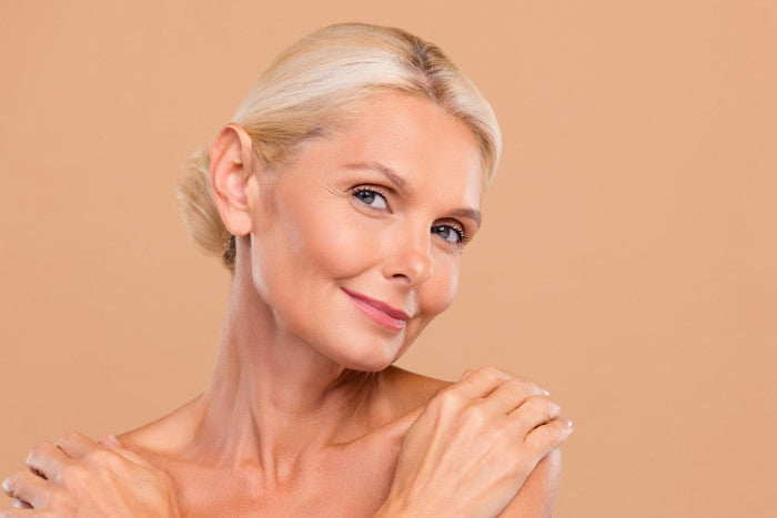 Reife Frau lächelt zufrieden nach einer Plisseefalten-Behandlung